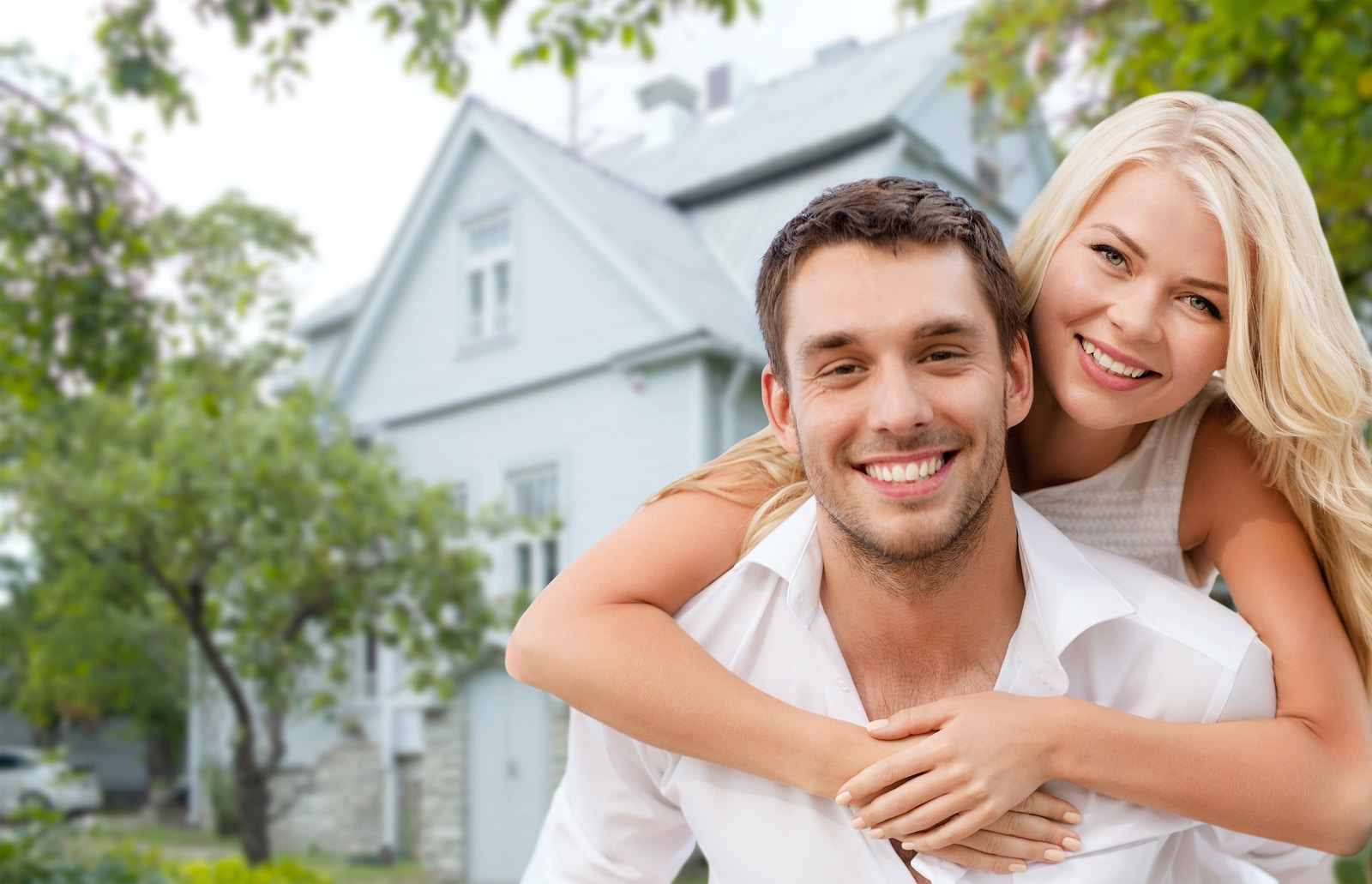 Smiling Couple with House in the background